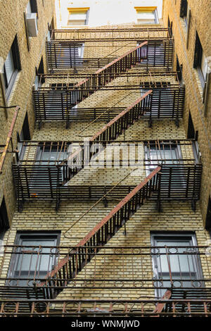 Fassade eines Brownstone mit einem alten rostigen Notausgang Stockfoto