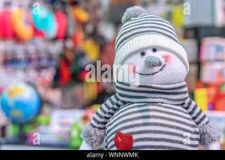Soft Toy lächelnd Schneemann in einem gestreiften Pullover und Hut. Stockfoto