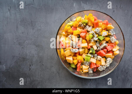 Frischer Salat mit exotischen Früchten closeup - Papaya, Mango, Ananas, Passionsfrucht, Dragon Obst, Trauben, lichee, Kiwi, Melone. Flach, Overhead Stockfoto