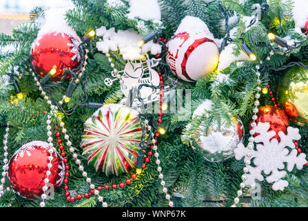 Der Weihnachtsbaum auf der Straße ist mit verschiedenen hellen Spielzeug und Schneeflocken dekoriert. Stockfoto