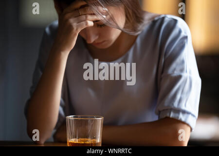 Close up unglückliche Frau allein sitzend Mit einem Glas Alkohol Stockfoto