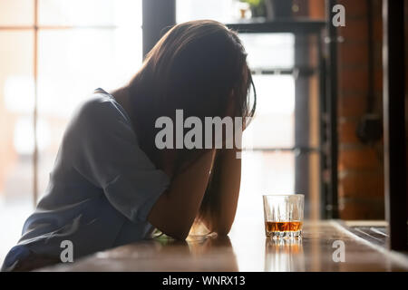 Lonely unglückliche Frau allein sitzend Mit einem Glas Alkohol Stockfoto