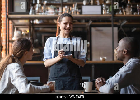 Attraktive Kellnerin an African American man Witz lachen, Kunden Stockfoto