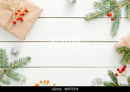 Weihnachten Komposition. Geschenke, Fir Tree Branches, rot Dekorationen auf Holz- weiß Schreibtisch. Weihnachten Hintergrund, Winter Urlaub, Neues Jahr. Wohnung La Stockfoto