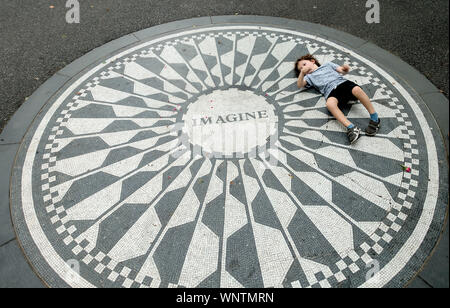 Ein Kind spielt auf dem Strawberry Fields Monument für John Lennon im Central Park, New York Stockfoto