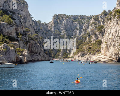 Kajaks, Boote, Schwimmer und genießen Sie das schöne blaue Wasser des Calanques in der Nähe von Cassis Frankreich. Stockfoto