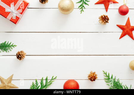 Weihnachten Komposition. Rot Geschenke, Dekorationen, Tannenbaum Äste, Tannenzapfen auf hölzernen weißen Hintergrund. Weihnachten, Winter Urlaub, neues Jahr. Stockfoto