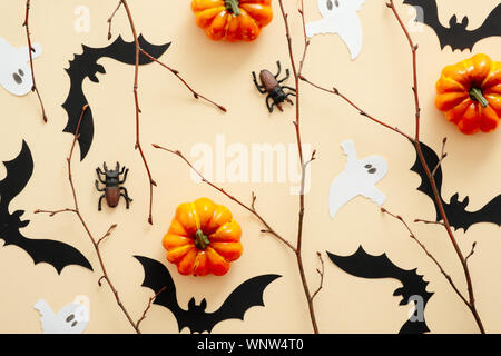 Happy Halloween Konzept. Halloween Dekoration, Kürbisse, Fledermäuse, Geister, Spinnen auf Pastell beige Hintergrund. Halloween Party Grußkarte mockup. Flach Stockfoto