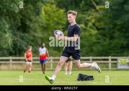 Junge männliche Rugbyspieler (Alter 150-25 jahre) laufen mit Rugby Ball in der Hand. Stockfoto