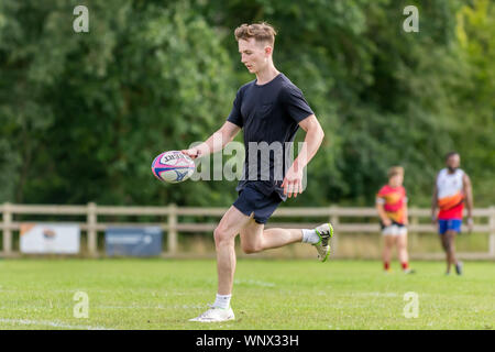 Junge männliche Rugbyspieler (Alter 150-25 jahre) laufen mit Rugby Ball in der Hand. Stockfoto