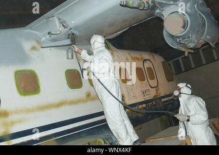 Handwerker Sprays der Rumpf auf eine Dornier 228 Flugzeugen Stockfoto