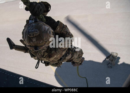 Eine zypriotische Nationalgarde Special Forces rutscht ein Seil während fast roping insertion Training mit US Air Force Special Taktik Betreiber während eifrig Lion 2019 bei König Abdullah II Special Operations Training Center, Haschemitisches Königreich Jordanien, Sept. 4, 2019. Spezielle Taktik ist in den USA eine spezielle Operation Befehl des Tactical Air- und Ground Integration in Kraft, und die Luftwaffe Masse Kraft, führender globaler Zugriff, Precision strike, Personal Recovery und Schlachtfeld Chirurgie Operationen auf dem Schlachtfeld. Eifrig, Lion, US Central Command der größte und komplexeste Übung, Stockfoto