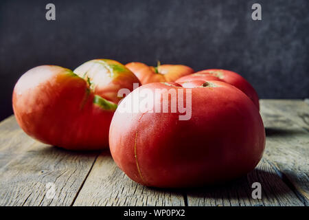Farbenfroh, frisch, große homegrown Tomaten auf einem alten Holztisch. Die Ernte. Stockfoto