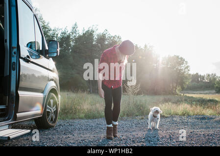 Frau gehen mit Ihrem Hund beim Camping in einem Wohnmobil im Sommer Stockfoto