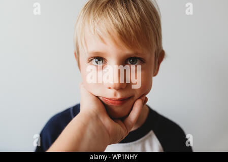 Liebevolle moment glücklicher Sohn mit der Mutter Hand sein Gesicht Stockfoto