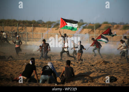 Gaza, Palästina. 06 Sep, 2019. Demonstranten aus tränengaskanister reißen die Flucht in Richtung zu Ihnen während einer anti-israelischen Demonstration an der Israel-Gaza Grenzzaun im südlichen Gazastreifen abgefeuert. Credit: SOPA Images Limited/Alamy leben Nachrichten
