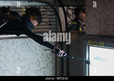 Hongkong, China. 06 Sep, 2019. Ein Demonstrant versucht ein Zeichen aus der Wand einer MTR Eingang zu rippen, während Sie ein Wandern der Pole während der Demonstration. regierungsfeindlichen Demonstranten auf die Straße gingen, wieder in der letzten Runde der anti-Auslieferung Demonstrationen. Die Demonstranten gezielt den Bereich um die 31 mtr Vorfall ereignete, vandalizing verschiedene MTR Station Eingang. Die Bereitschaftspolizei kam schließlich und führte eine Zerstreuung. Credit: SOPA Images Limited/Alamy leben Nachrichten Stockfoto