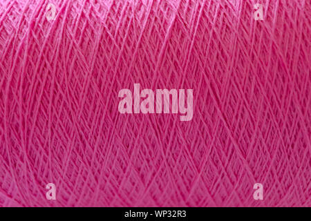 Nahaufnahme von thread Wunde am Steuerschieber . Fuchsia Farbe Hintergrund. Stockfoto