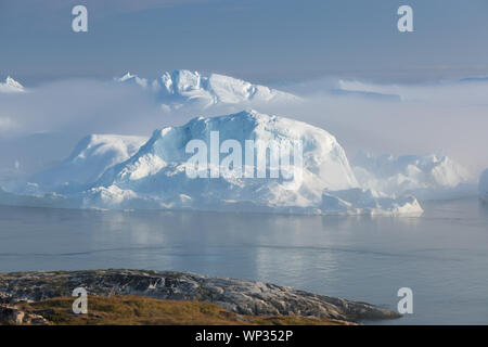 Gestrandete Eisberge im Nebel an der Mündung der Eisfjord in der Nähe von Ilulissat. Natur und Landschaft Grönlands. Reisen auf dem Schiff unter Ices. Stockfoto