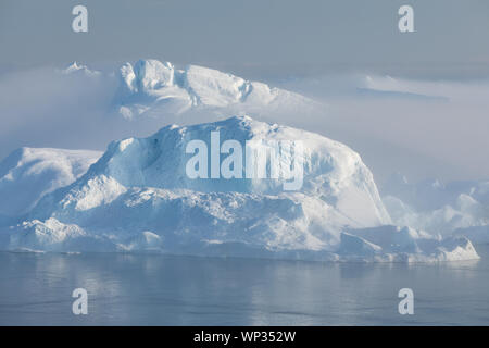 Gestrandete Eisberge im Nebel an der Mündung der Eisfjord in der Nähe von Ilulissat. Natur und Landschaft Grönlands. Reisen auf dem Schiff unter Ices. Stockfoto