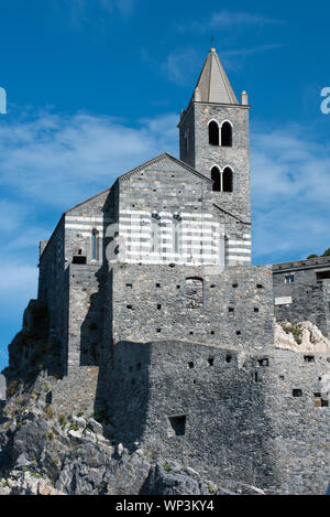 Low Angle View der historischen St. Peter Kirche in Portovenere, Ligurien, Italien thront auf den Felsen vor einem blauen sonnigen Himmel Stockfoto