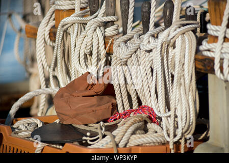 Wunde und ordentlich verstaut Seile oder Bindfäden für die takelage auf eine alte hölzerne Segelboot unter den Mast in der Nähe zu detaillierte Ansicht Stockfoto