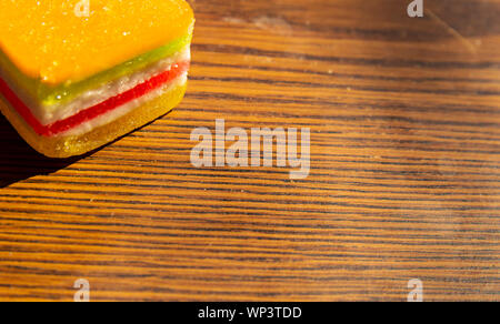 Dessert - Marmelade in einem mehrfarbigen Streifen auf einem Holz- Hintergrund, ein Platz für den Text Stockfoto