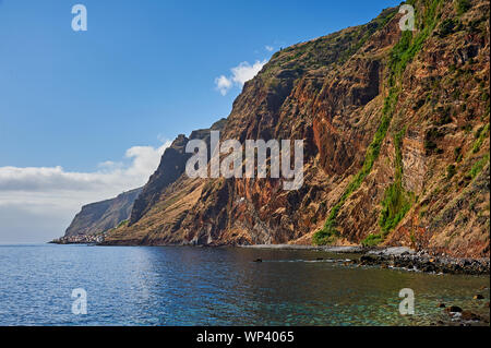 Die südliche Küste der Insel Madeira umfasst isolierte Dörfer am Fuße des umfangreichen Klippen. Stockfoto