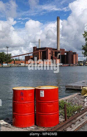Red Oil Drums auf Sompasaari bereits benutzt, Kai, hanasaari Kraftwerk im Hintergrund, in Helsinki, Finnland Stockfoto