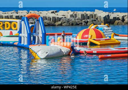 Calheta, Madeira und aufblasbaren Hindernisse Schwimmer im künstlichen Hafen. Stockfoto