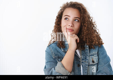 Hmm interessanter Gedanke. Attraktive plumpen Körper - positive verträumt lockigen dunkelhaarigen Mädchen Jeansjacke denken Nachdenken über interessante Wahlen Kommissionierung mitnehmen. Stockfoto