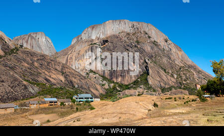 Kleines Dorf im südwestlichen Hochland von Madagaskar mit typischen Backstein Gras strohgedeckten Häusern Anbau von Reis und Berge Stockfoto