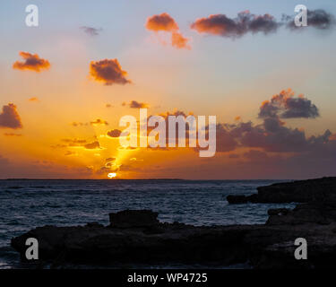 Sonnenuntergang mit Lichtstrahlen über den Kanal von Mosambik von einem Strand in der Nähe von Andavadoaka, South West Madagaskar genommen. Silhouetten von Coral rocks Stockfoto