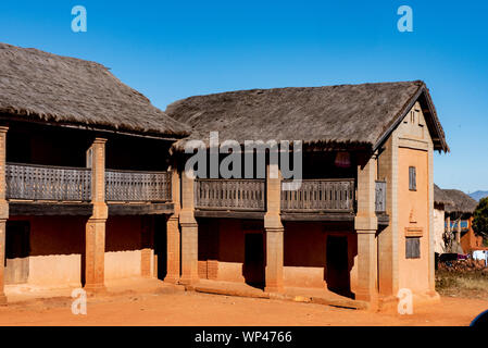 Typische traditionelle lehmziegel aus lehmziegeln gebaut strohgedeckten zweistöckigen Häusern in einem kleinen Dorf im zentralen Hochland von Madagaskar. Tief orange braune Ziegel Stockfoto