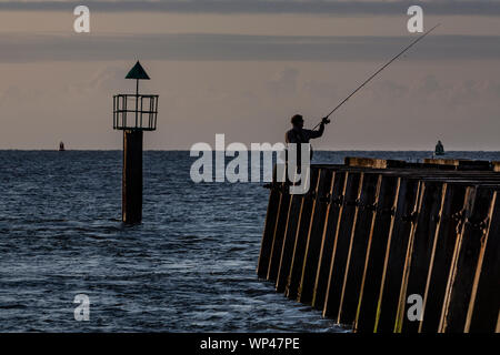 Ein Fischer bereitet von einem Pier zu werfen. Stockfoto