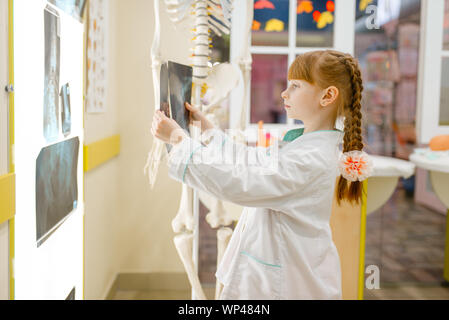 Kleine Mädchen in Uniform sieht sich die x-ray, Arzt Stockfoto