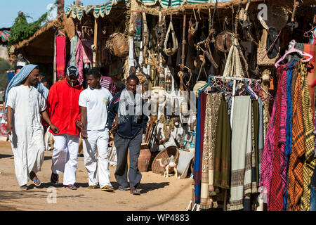 Männer gehen durch die vielen Stände, Merchandise und Souvenirs in der nubischen Dorf Garb-Sohel in der Region Assuan in Ägypten. Stockfoto