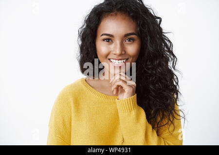 Emotionen, Glück und Schönheit Konzept. Attraktive curly - behaarte Frau in gelb Pullover lächelt erfreut, wie das, was Sie als richtige Wahl sehen, Tou Stockfoto