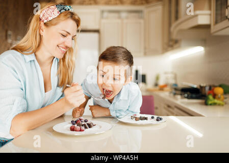 Mutter mit Kind Verkostung Dessert und Spaß Stockfoto