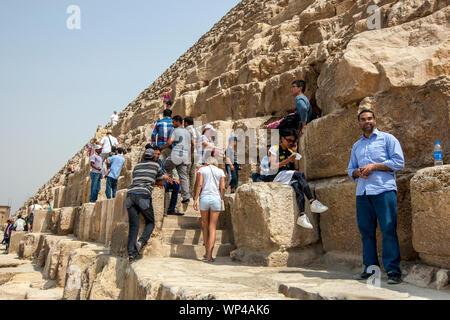 Besucher der Pyramiden von Gizeh bei Kairo in Ägypten Aufstieg über die riesigen sandsteinblöcken der Cheops-pyramide. Stockfoto