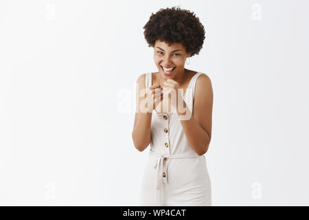 Lass uns Kämpfen kommen. Portrait von verspielt und fröhlich unbeschwerten afrikanische amerikanische Freundin mit Afro Frisur die geballten Fäuste auf der Brust in Feld Stockfoto