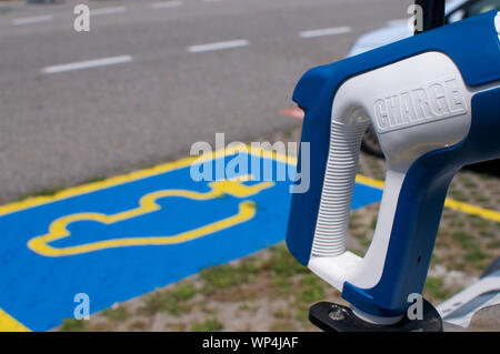 In der Nähe Bild von einer elektrischen Stecker Ladegerät für Fahrzeuge mit elektrischen Ladegerät, Docking Station auf dem Parkplatz gezeichnet. In der Vill erfasst Stockfoto