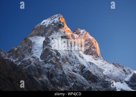 Berg bei Sonnenaufgang. Berg Ushba, Swaneti, Georgien, Kaukasus. Die ersten Strahlen der Sonne. Schönheit in der Natur Stockfoto