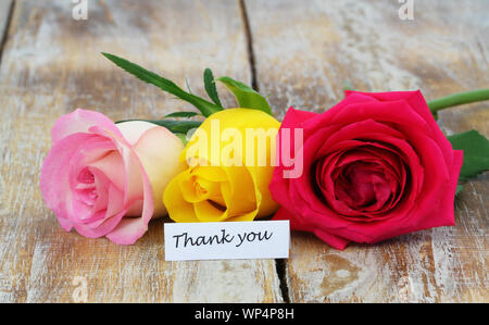 Danke Karte mit drei bunten Rosen auf Holzmöbeln im Landhausstil Oberfläche Stockfoto