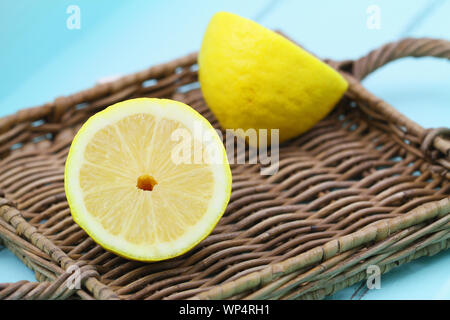 Die beiden Hälften des reife Zitrone auf wicker Fach Stockfoto