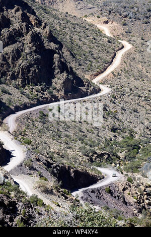 Auto fahren auf einem staubigen Feldweg in den Bergen in der Nähe von Balad Sayt, Oman Stockfoto