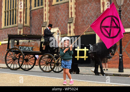 Clementine Reid Wellen eine Exinction Rebellion Flagge vor Töten Radfahrer Demonstranten Inszenierung eine symbolische Beerdigung in Lincoln's Inn Fields, während einer Radfahren Protest in London. Stockfoto