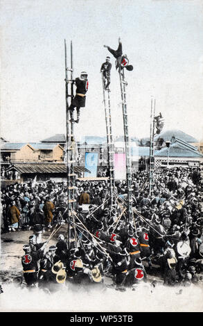 [1900s Japan - Japanische Feuerwehrmänner] - Feuerwehrmänner in happi Mäntel durchführen akrobatischen Stunts auf Bambus Leitern bei Yoshidabashi in Yokohama. Die Leiter Stunts waren die wichtigsten Ereignis der Japanischen ins neue Jahr feiern. Die Demonstrationen, die sogenannten Dezome-shiki, waren dazu gedacht, die Menschen auf die Gefahren des Feuers zu warnen und die Flexibilität und den Mut der Feuerwehrleute zu demonstrieren. 20. jahrhundert alte Ansichtskarte. Stockfoto