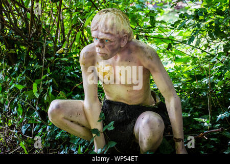 Ein Kunststoff Modell des Neandertalers im Waldland Szene bei Wookey Hole, Somerset, Großbritannien Stockfoto