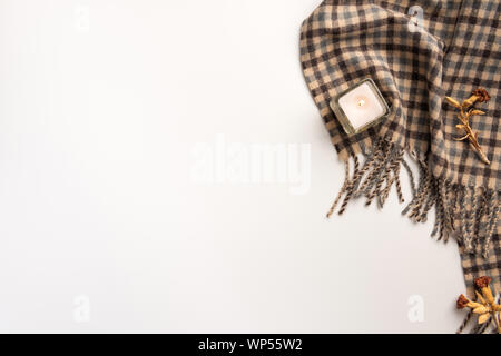 Warmer Schal und Kerze, auf weißem Hintergrund. Flach. Stockfoto